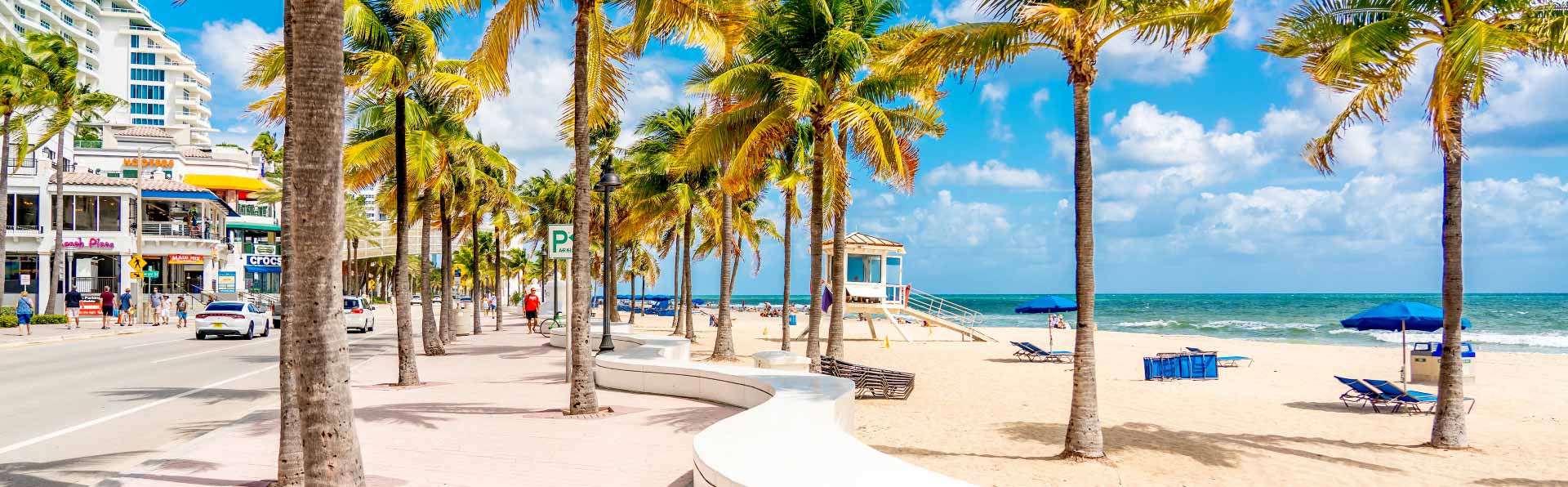 shops and walking path with palm trees alongside Florida beach
