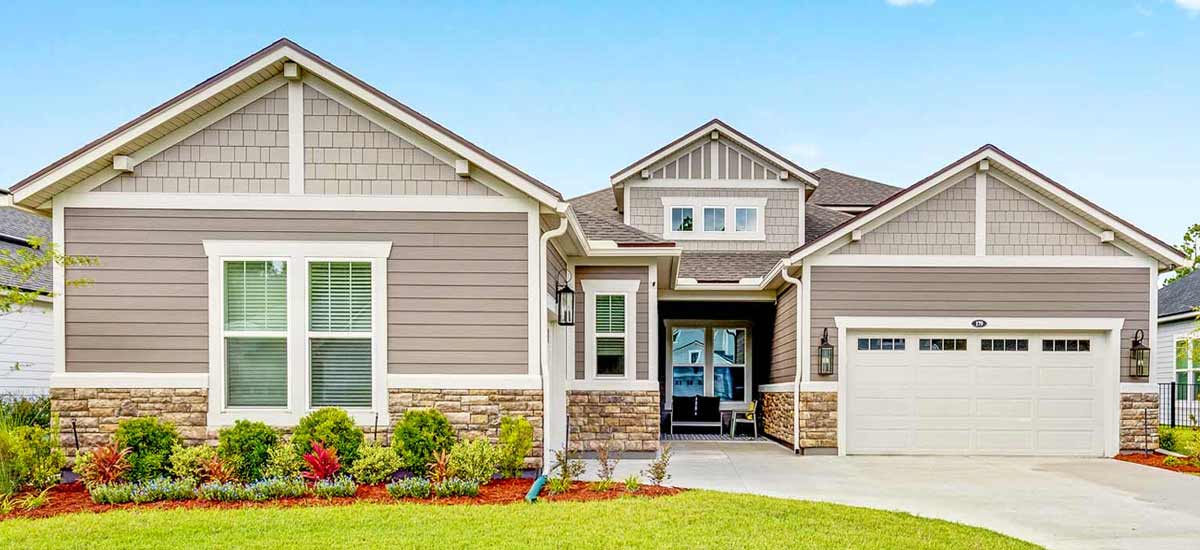 modern single-story home of earth tone colors with new landscape 