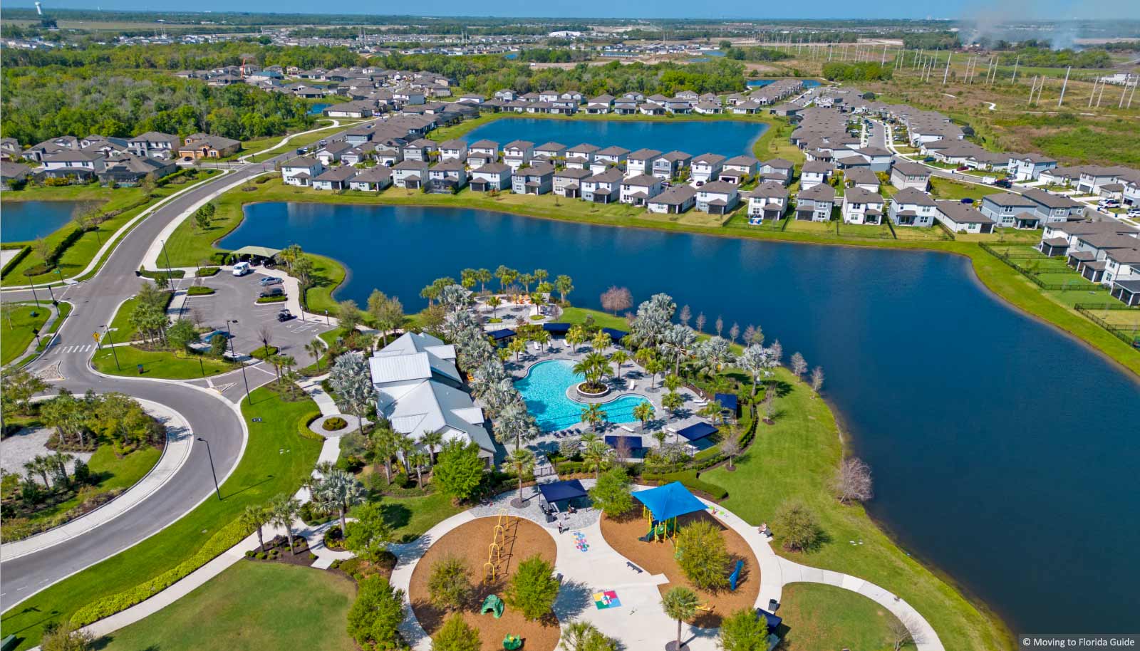 Community pool and play area overlooking a lake and homes