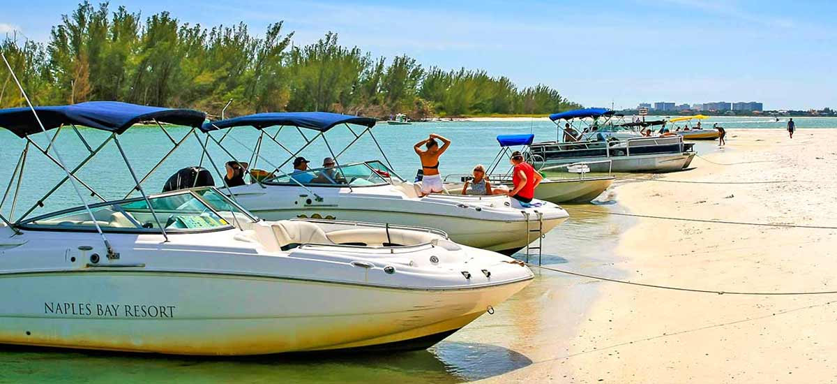 small boats perched on a sand bar island on sunny day