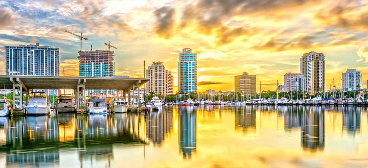 tall buildings in St Pete skyline at sunset reflecting on water